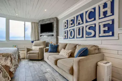 a living room with a couch and a television at Seaside Villa - Ocean View Studio in Panama City Beach