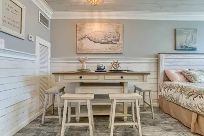 a bedroom with a desk and stools next to a bed at Seaside Villa - Ocean View Studio in Panama City Beach