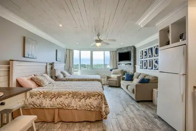 a bedroom with a bed and a couch at Seaside Villa - Ocean View Studio in Panama City Beach