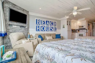 a bedroom with a bed and a couch and a tv at Seaside Villa - Ocean View Studio in Panama City Beach