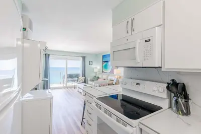 a kitchen with white appliances and a view of the ocean at Once Upon A Dream - Beachfront Bliss in Panama City Beach