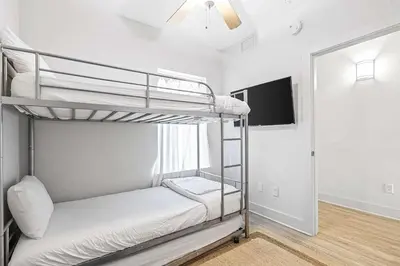 a bedroom with two bunk beds and a mirror at Salt and Shore Escape - Sleeps 7 in Panama City Beach