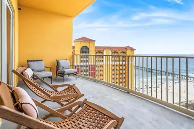 a balcony with rocking chairs and the ocean at Salt and Shore Escape - Sleeps 7 in Panama City Beach