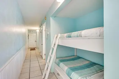 a room with two bunk beds and a ladder at Beach Bliss Family Beachfront Living in Panama City Beach