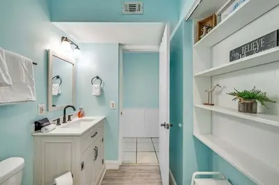 a bathroom with a white sink and a blue wall at Beach Bliss Family Beachfront Living in Panama City Beach