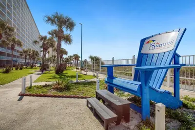 a giant blue chair sitting next to a park at Beach Bliss Family Beachfront Living in Panama City Beach