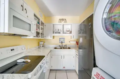 a kitchen with white cabinets and a sink at Beach Bliss Family Beachfront Living in Panama City Beach