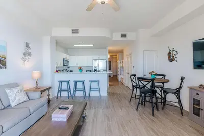 a living room and kitchen with a couch and a table at Sandy Feet Retreat - Ocean View Condo in Panama City Beach