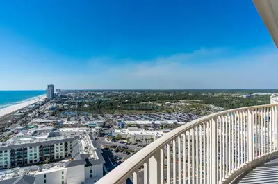 a view of the beach from the balcony of a building at Sandy Feet Retreat - Ocean View Condo in Panama City Beach
