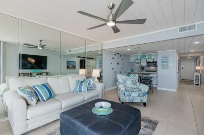 a living room with a white couch and a table at Beachfront Days Ocean View Condo Bliss in Panama City Beach