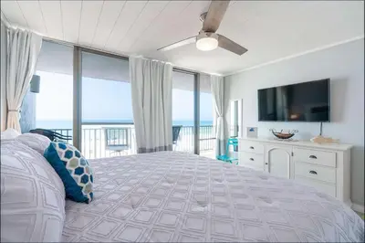 a bedroom with a bed with a view of the ocean at Beachfront Days Ocean View Condo Bliss in Panama City Beach