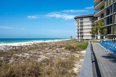 a boardwalk leading to the beach and a building at Beachfront Days Ocean View Condo Bliss in Panama City Beach