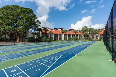 a tennis court in front of a building at Beachfront Days Ocean View Condo Bliss in Panama City Beach