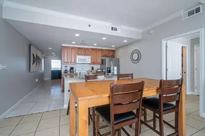 a kitchen and dining room with a wooden table and chairs at Beachfront Haven 2 BDR Kid-Friendly Resort in Panama City Beach