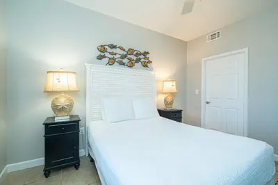 a bedroom with a white bed and two lamps at Beachfront Haven 2 BDR Kid-Friendly Resort in Panama City Beach
