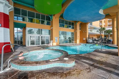 a large swimming pool in a building with a man in it at Beachfront Haven 2 BDR Kid-Friendly Resort in Panama City Beach