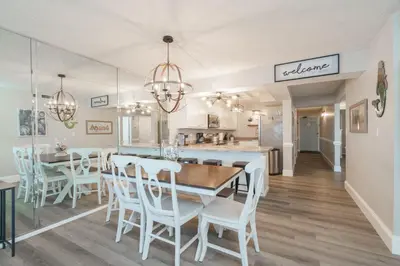 a kitchen and dining room with a table and chairs at Bethys Beachy Beauty Regency Towers in Panama City Beach