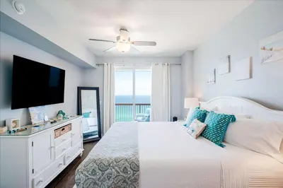 a bedroom with a bed and a flat screen tv at Sunrise Sands - An Unforgettable Vacation for 7 in Panama City Beach