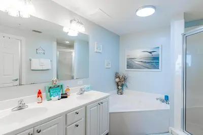 a bathroom with two sinks and a bath tub at Sunrise Sands - An Unforgettable Vacation for 7 in Panama City Beach