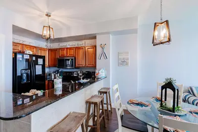 a kitchen with a counter and a table with chairs at Sunrise Sands - An Unforgettable Vacation for 7 in Panama City Beach