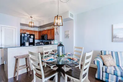 a kitchen and dining room with a table and chairs at Sunrise Sands - An Unforgettable Vacation for 7 in Panama City Beach