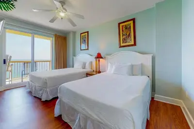 a bedroom with two beds and a ceiling fan at Sunrise Serenity - Resort Condo in Panama City Beach
