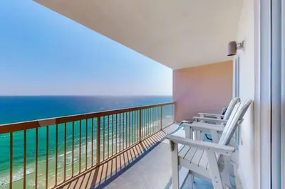 a balcony with two chairs and the ocean at Sunrise Serenity - Resort Condo in Panama City Beach