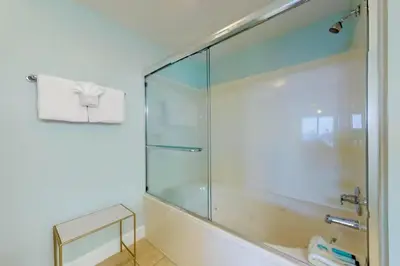 a shower with a glass door in a bathroom at Sunrise Serenity - Resort Condo in Panama City Beach