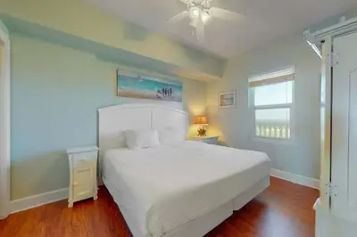 a bedroom with a white bed and a window at Sunrise Serenity - Resort Condo in Panama City Beach