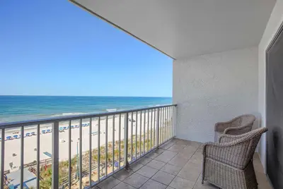 a balcony with two chairs and a view of the beach at Sunrise Sunset - Full Ocean Views in Panama City Beach