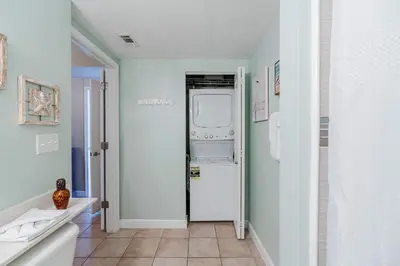 a kitchen with a washer and dryer in a room at Sunset Shores - Oceanfront Condo Bliss in Panama City Beach