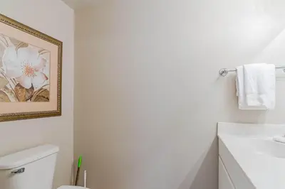 a bathroom with a white toilet and a sink at Sunset Shores - Oceanfront Condo Bliss in Panama City Beach