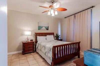 a bedroom with a bed and a ceiling fan at Sunset Shores - Oceanfront Condo Bliss in Panama City Beach