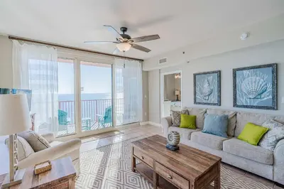 a living room with a couch and a table at Sunset Shores - Oceanfront Condo Bliss in Panama City Beach