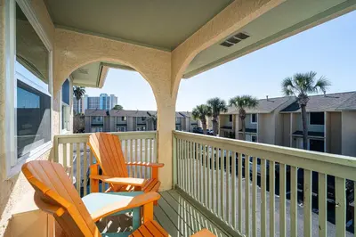 two chairs on a balcony with a view of a city at The Turtle Nest - Resort Condo with Pool in Panama City Beach
