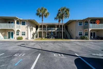 an empty parking lot in front of a building at The Turtle Nest - Resort Condo with Pool in Panama City Beach