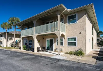 a large house with a balcony on a street at The Turtle Nest - Resort Condo with Pool in Panama City Beach