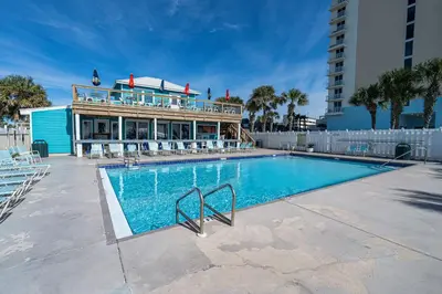 a swimming pool with a building in the background at The Turtle Nest - Resort Condo with Pool in Panama City Beach