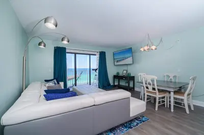 a living room with a white couch and a table at Turtle Love - Resort Amenities & Ocean Views in Panama City Beach