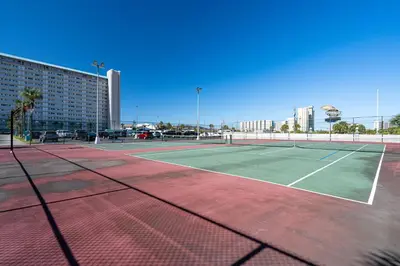 a tennis court in front of a building at Turtle Love - Resort Amenities & Ocean Views in Panama City Beach