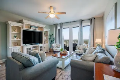 a living room with couches and a flat screen tv at Whitesands Retreat - Incredible Resort Home in Panama City Beach