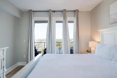 a bedroom with a bed and a large window at Whitesands Retreat - Incredible Resort Home in Panama City Beach