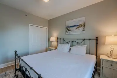 a bedroom with a bed with white sheets and two lamps at Whitesands Retreat - Incredible Resort Home in Panama City Beach