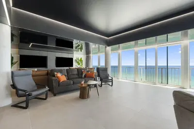 a living room with a couch and chairs and windows at The Summit Penthouse 1501 in Panama City Beach