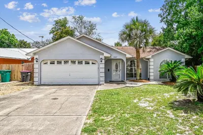 a house with a garage and a palm tree at 17007 Firenzo Ave home in Panama City Beach