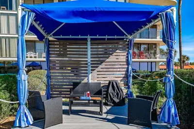 a blue gazebo with chairs and a table at Luxe Gulf Front View with Free Beach Chairs, Balcony, & Resort Amenities in Panama City Beach