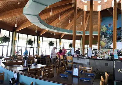 a restaurant with people sitting at the bar at Luxe Gulf Front View with Free Beach Chairs, Balcony, & Resort Amenities in Panama City Beach