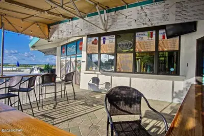 a bar with chairs and tables on a patio at Luxe Gulf Front View with Free Beach Chairs, Balcony, & Resort Amenities in Panama City Beach