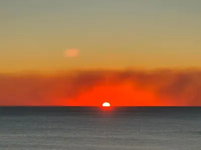 a sunset over the ocean with the sun in the horizon at Luxe Gulf Front View with Free Beach Chairs, Balcony, & Resort Amenities in Panama City Beach