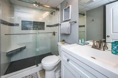 a bathroom with a toilet and a glass shower at Luxe Gulf Front View with Free Beach Chairs, Balcony, & Resort Amenities in Panama City Beach